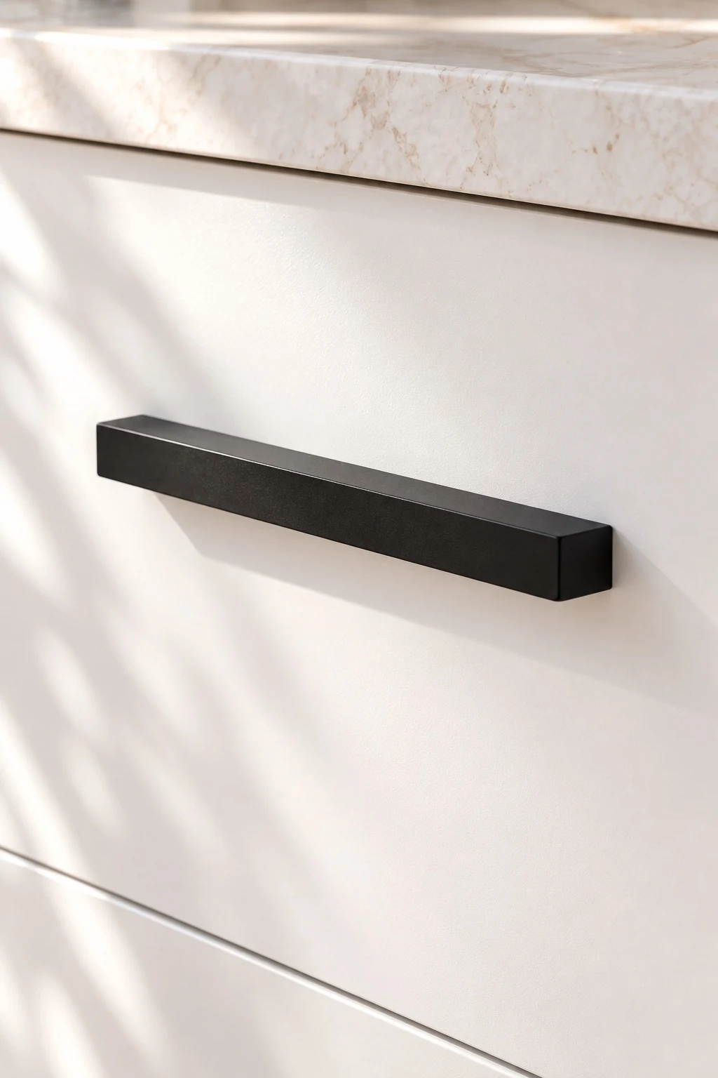 A close detail of matte black kitchen handles